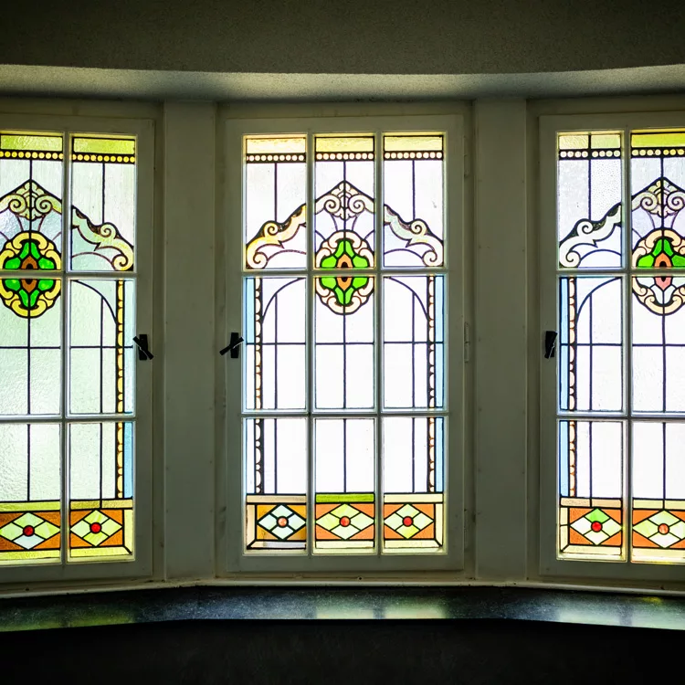 Eine Fensterreihe mit künstlerisch verzierten Fensterscheiben.